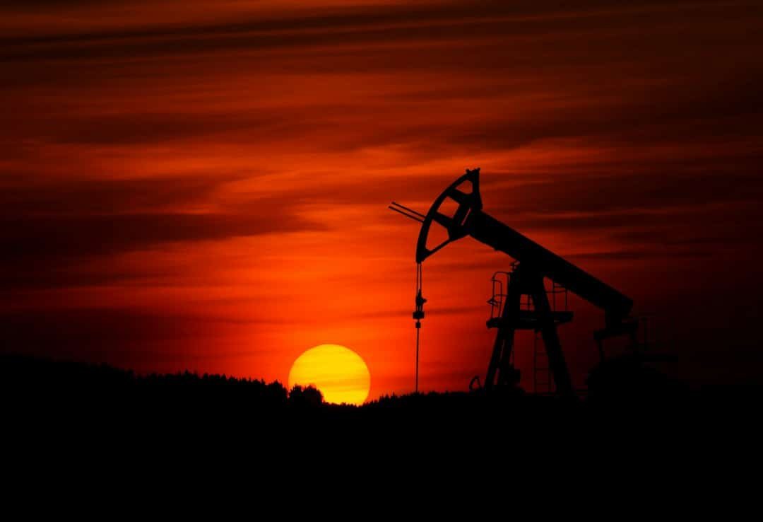 Oil pumpjack at sunset representing global oil markets